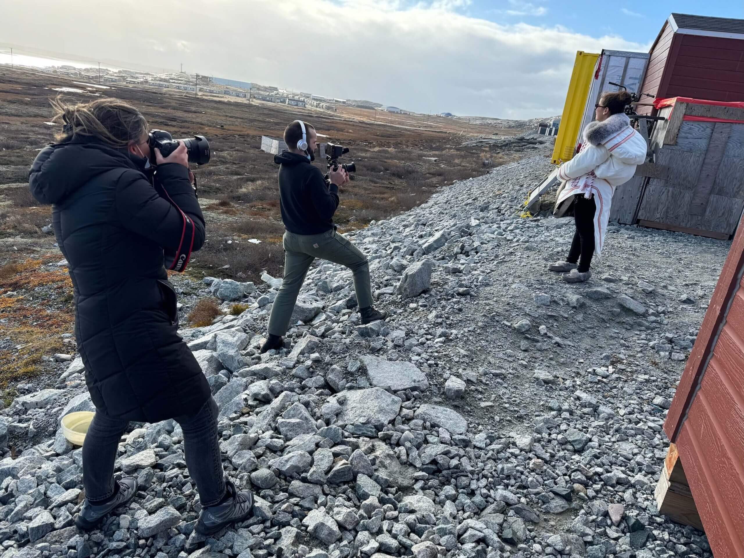 Two photographers and their subject on a rocky slope