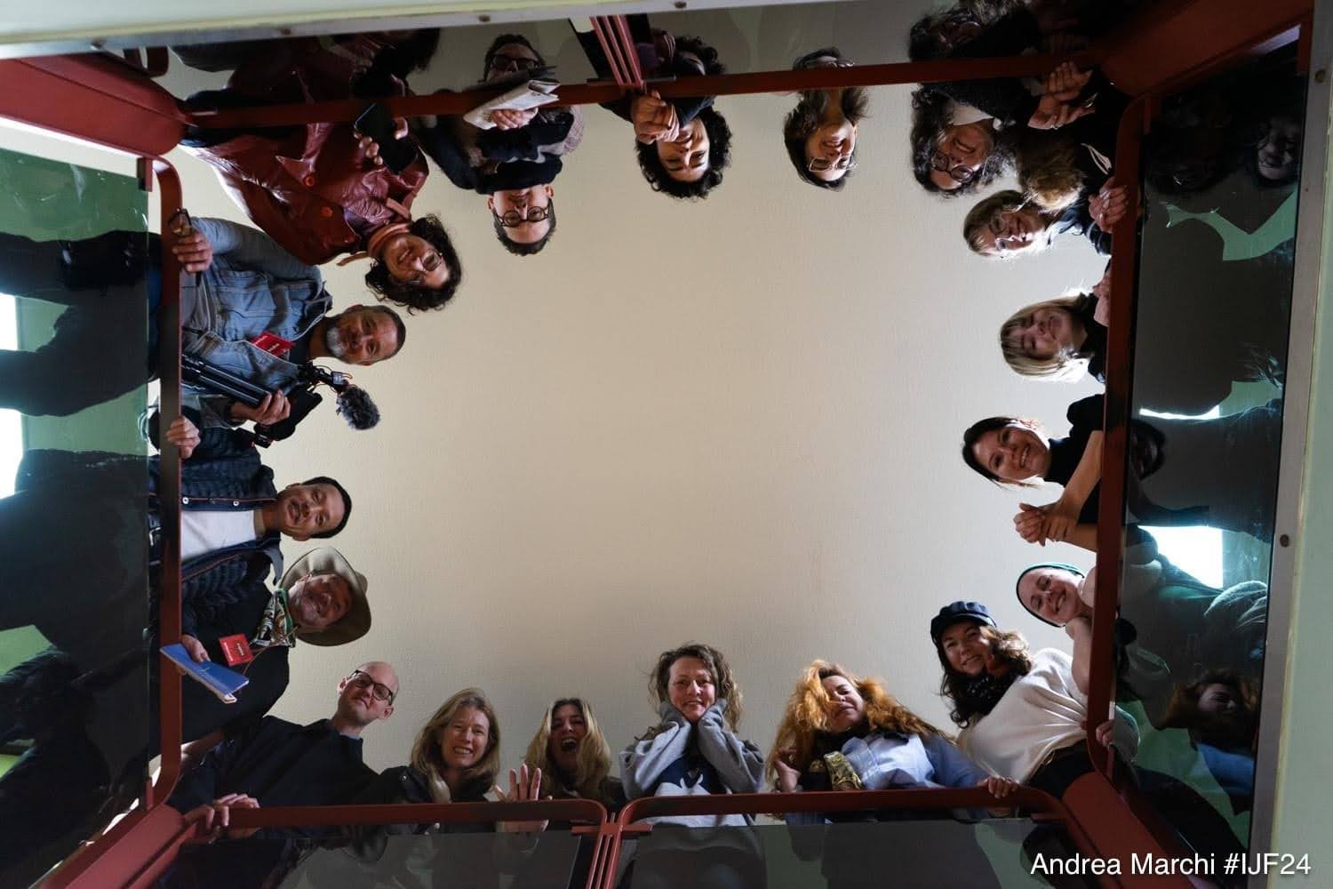 Group of people posing and smiling in a stairwell